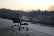 An empty park bench at dusk represents declining social interaction, reflecting recent data on Australians seeing friends.
