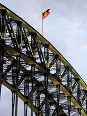 A view of the Australian Aboriginal flag on Sydney Harbour Bridge, illustrating issues of inequality.