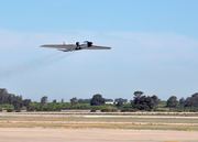A NASA WB-57 high altitude research aircraft takes off from an airfield.