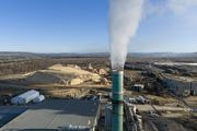 A pulp mill steam plume rises into the air.