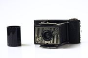 A vintage Ensign Midget camera is shown alongside a type 135 film roll, relating to culture and media.